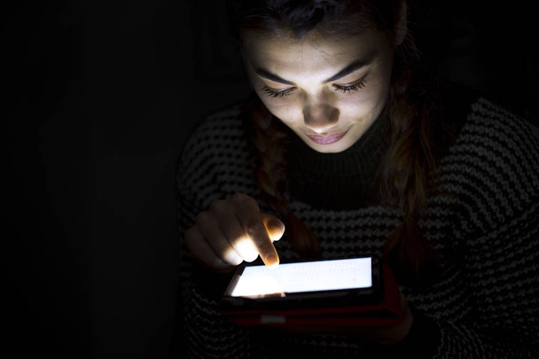 Γυναίκα χρησιμοποιώντας ψηφιακό tablet στο σκοτεινό θάλαμο - Φωτογραφία, εικόνα
