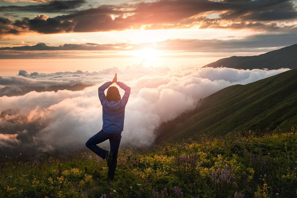 mulher nas montanhas durante um exercício de madrugada nebulosa no ioga
 - Foto, Imagem