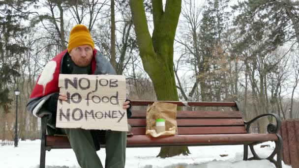   4 k. bezdomovec v zimě městského parku s karton, žádná práce, žádné peníze, žádné jídlo - Záběry, video