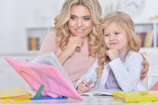 mother and daughter doing homework - Фото, изображение