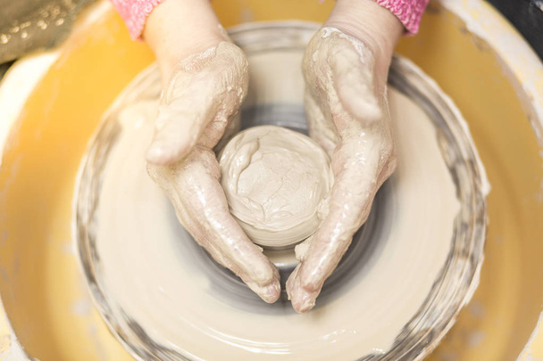 Child making her jar on a pottery wheel - Фото, изображение