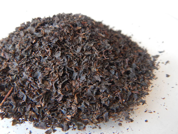 pequeño montón de hojas de té negro
 - Foto, imagen
