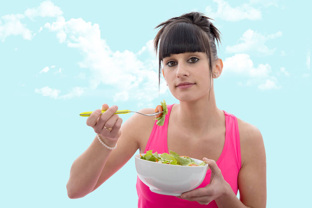Nuori brunette nainen syö salaattia
 - Valokuva, kuva
