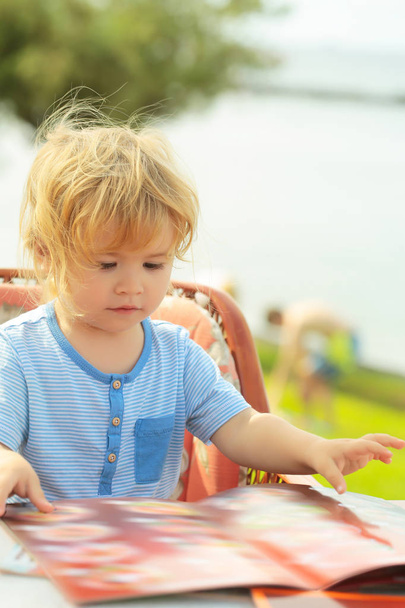 Cute baby boy reads menu card - Zdjęcie, obraz