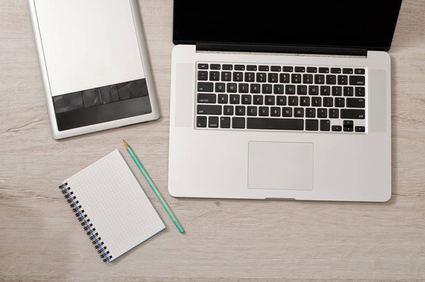 Aprire il computer portatile, tablet grafico e notebook con matita su un tavolo leggero, vista dall'alto
 - Foto, immagini