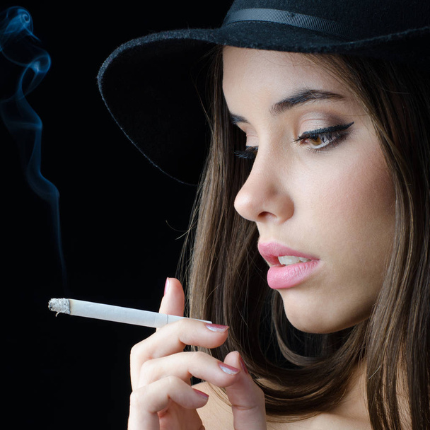 Portret van de mooie elegante meisje Rookvrije sigaret geïsoleerd op zwarte achtergrond - Foto, afbeelding