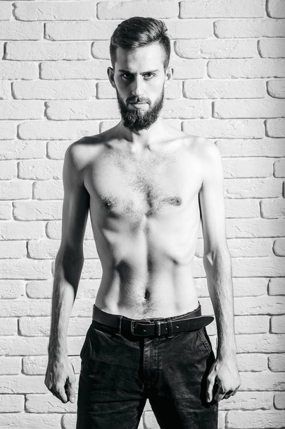 slim bearded man with thin bare torso on brick background - Foto, Bild