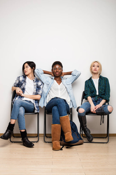 three different ethnic women waiting in line for interview - 写真・画像