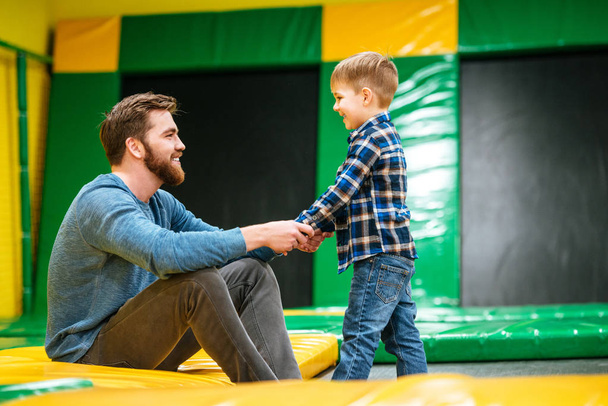 Father playing with his little son at indoor amusement park - Foto, afbeelding
