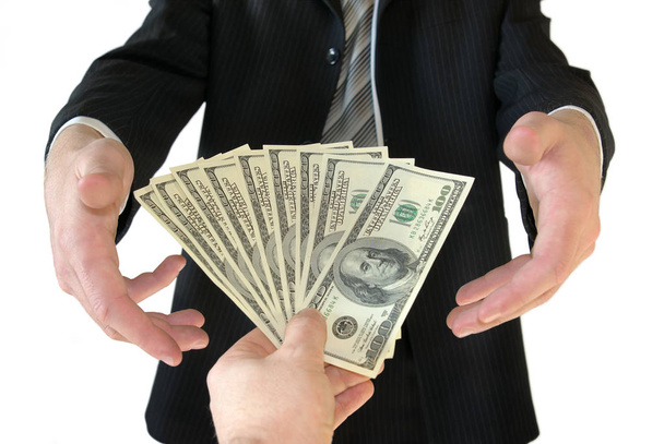 Homme en costume d'affaires noir, tenant de l'argent dans les mains
 - Photo, image
