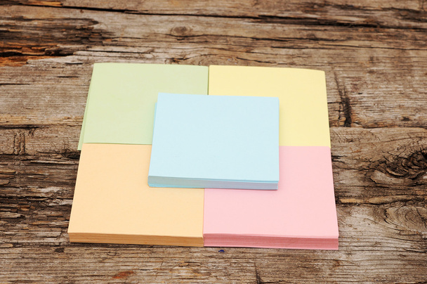 στοίβα από πολύχρωμα κολλώδεις σημειώσεις σε ξύλινα φόντο - Φωτογραφία, εικόνα