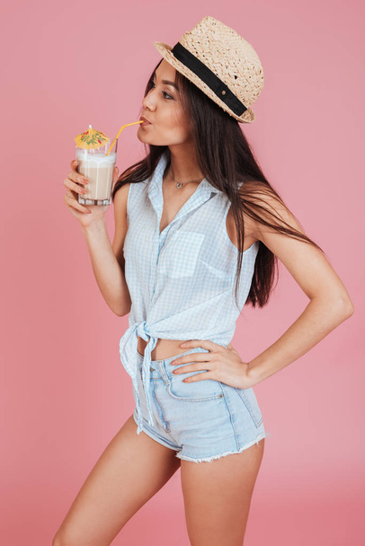 Young woman wearing hat drinking cocktail. - Φωτογραφία, εικόνα