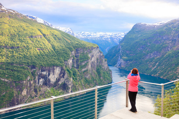 Tourist looking at Geirangerfjord from Flydasjuvet viewpoint Norway - Foto, immagini