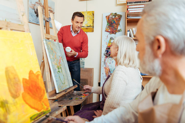 Man teaching people in painting studio. - Foto, imagen