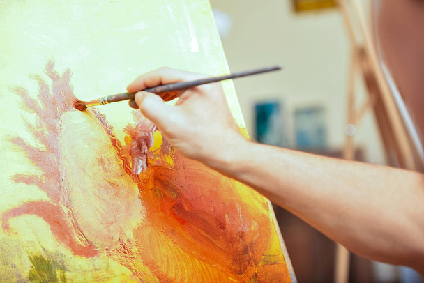 Close up of artists hand painting picture in cozy studio - Photo, Image