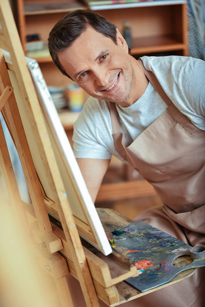Happy artist posing in painting studio. - Foto, imagen