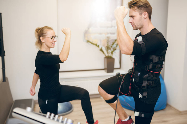 Young sportsman doing ems training with personal trainer - Foto, Bild