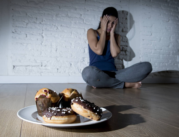unhealthy sugar donuts and muffins and tempted young woman or te - Photo, Image