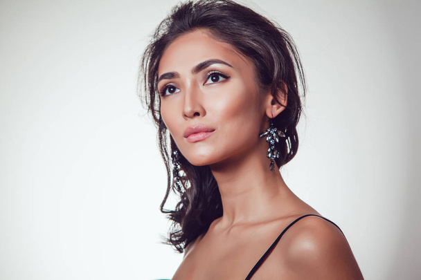 Glamour portrait of beautiful woman with earrings and fresh daily makeup on grey background. - Foto, Imagem