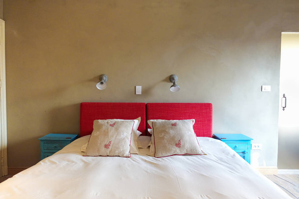Beautiful sleeping bed in comfortable bedroom with large windows - Foto, immagini