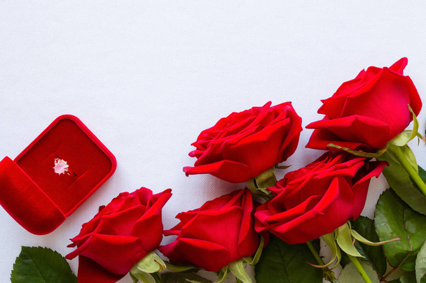 bouquet of red roses and a wedding ring on a white background with space for text - Fotó, kép