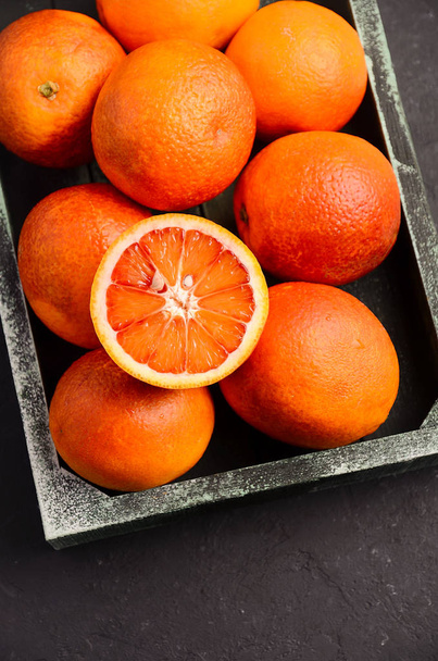 Кровавые апельсины в деревянном подносе на темном фоне
 - Фото, изображение