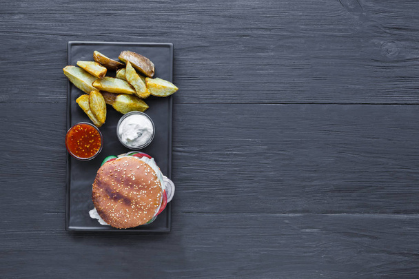 Fast food restaurant dish. Hamburger and potato wedges - Foto, Bild