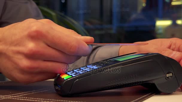 Un hombre pone una tarjeta de crédito a un escáner - primer plano
 - Metraje, vídeo