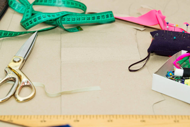 Naaien textiel of doek. De tabel van het werk van een kleermaker. Schaar, meten van tapes - Foto, afbeelding