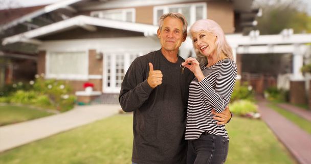Счастливые новые пожилые домовладельцы улыбаются на камеру
 - Фото, изображение