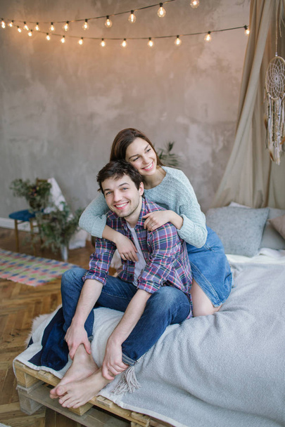 Young hipster couple reading magazine on handmade bed with dream - Фото, зображення