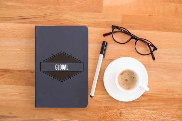 Notebook, cup ang glasses on desk.  - Foto, afbeelding