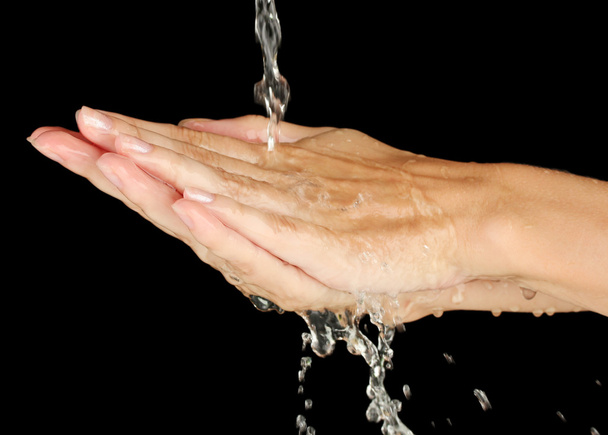 Washing hands on black background close-up - 写真・画像
