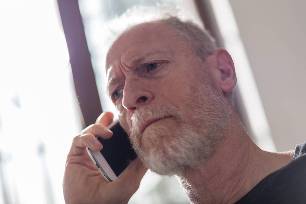Senior man talking on phone, hard light effect - Photo, Image