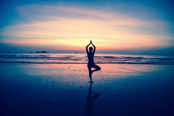 Jonge vrouw die yoga beoefent - Foto, afbeelding