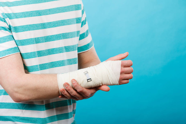 Man with painful bandaged hand. - Foto, afbeelding