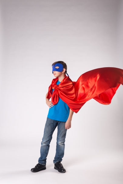 Criança de super-herói em capa vermelha balançando no vento
 - Foto, Imagem