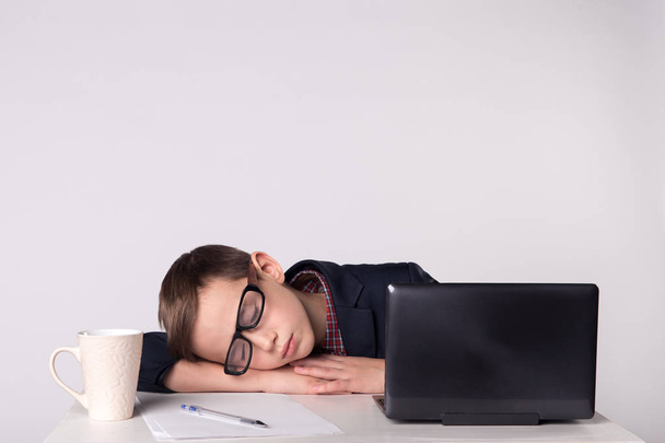 Niño empresario se cansa y se queda dormido
 - Foto, Imagen