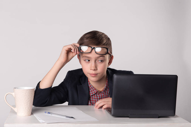 Young playful business kid looking at the laptop - Foto, imagen