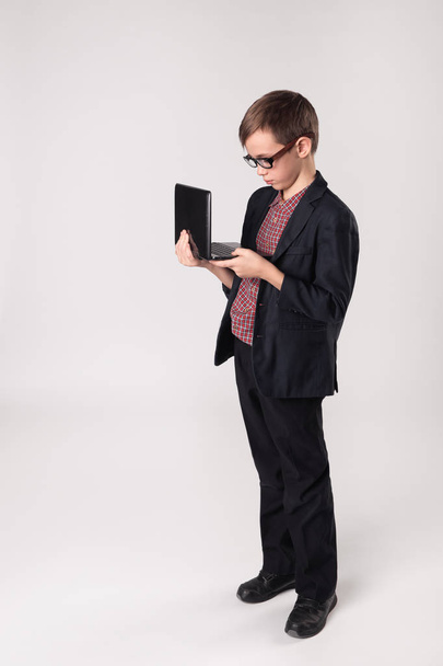 menino de negócios em um terno trabalhando no laptop
 - Foto, Imagem