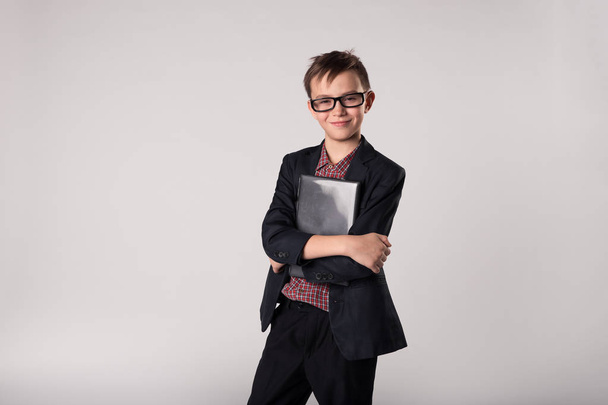 Business kid holding laptop in his hands - Фото, изображение