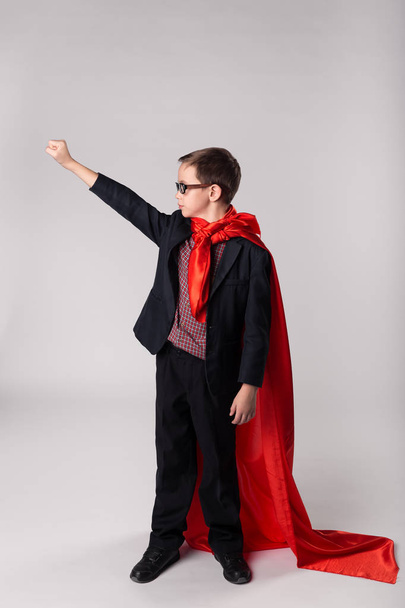 Young business kid hand up in superman cape - Фото, зображення