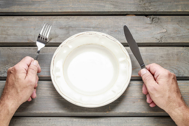 Hungry man waiting for his meal over empty plate - Foto, Imagen