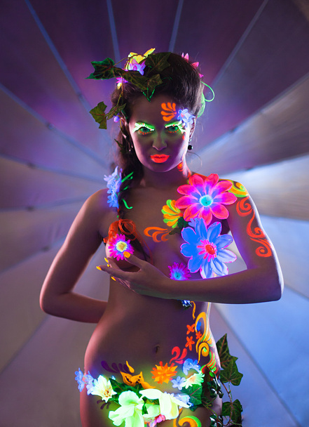 Beauty woman with glowing make-up posing in dark - Фото, зображення
