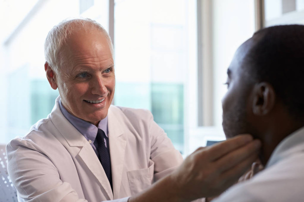 Doctor examining male patient - Φωτογραφία, εικόνα