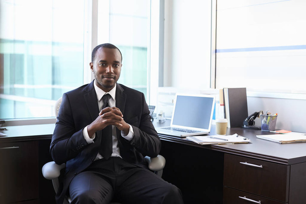 Man in suit sitting at desk - Фото, изображение