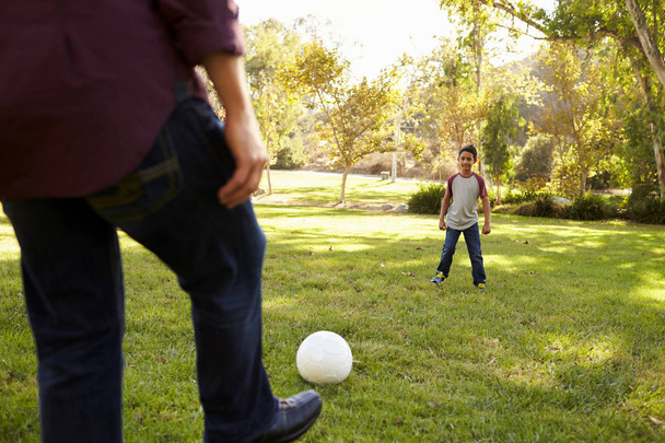 Dad kicking ball to son - Foto, Bild