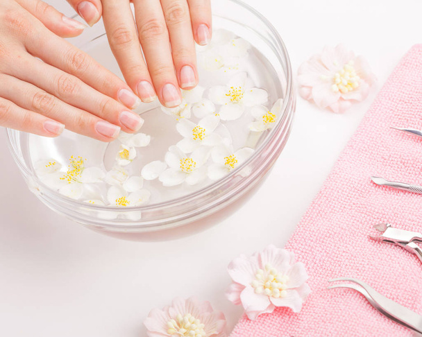 Beautiful womans hands with manicure in bowl of water - 写真・画像