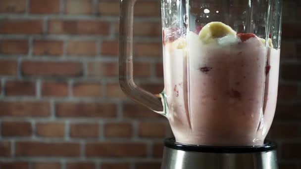 Blender egy banán strawberry tej smoothie a konyhában, lassú mozgás - Felvétel, videó
