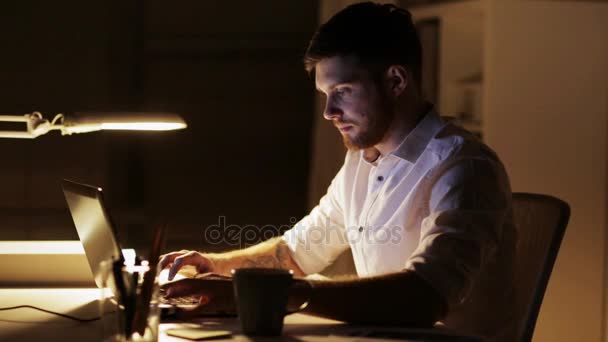 man with laptop finishing work at night office - Кадры, видео